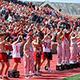 A crowd of young men stand in bleachers in Little Giant Stadium